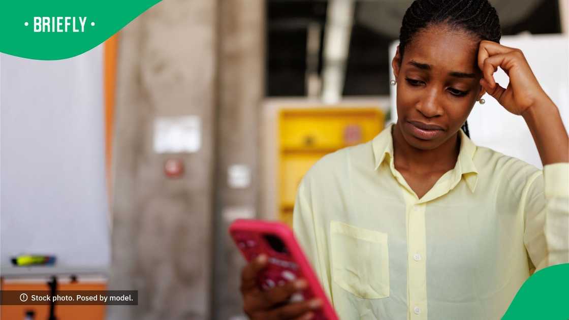 A confused woman looking at her phone. A confused woman looking at her phone.