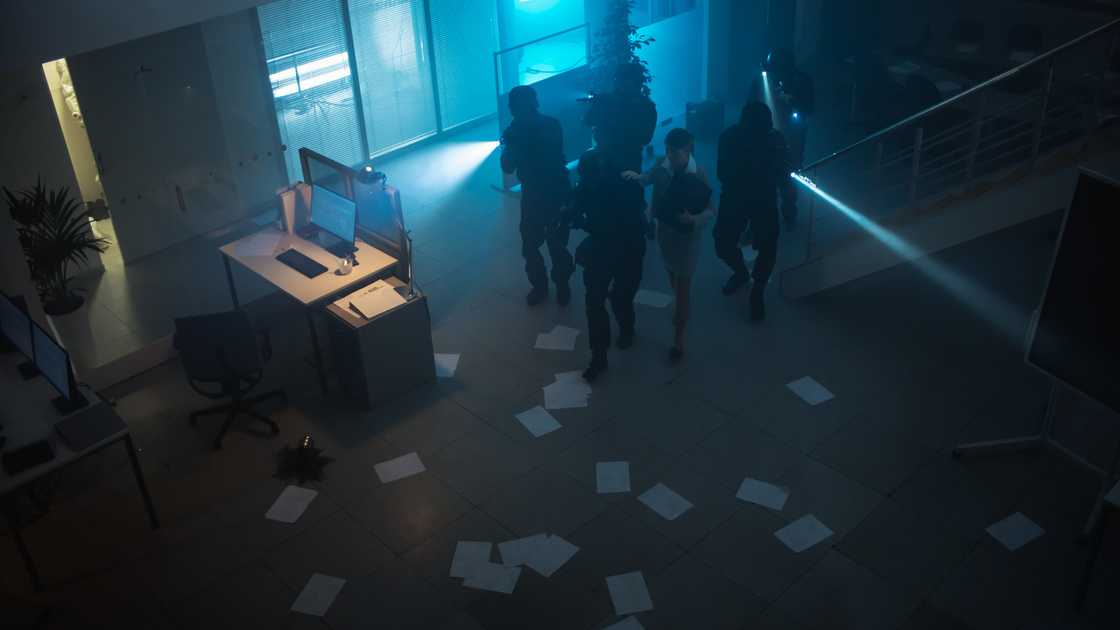 Police enter an office as a businessman freezes in place. Police enter an office as a businessman freezes in place.