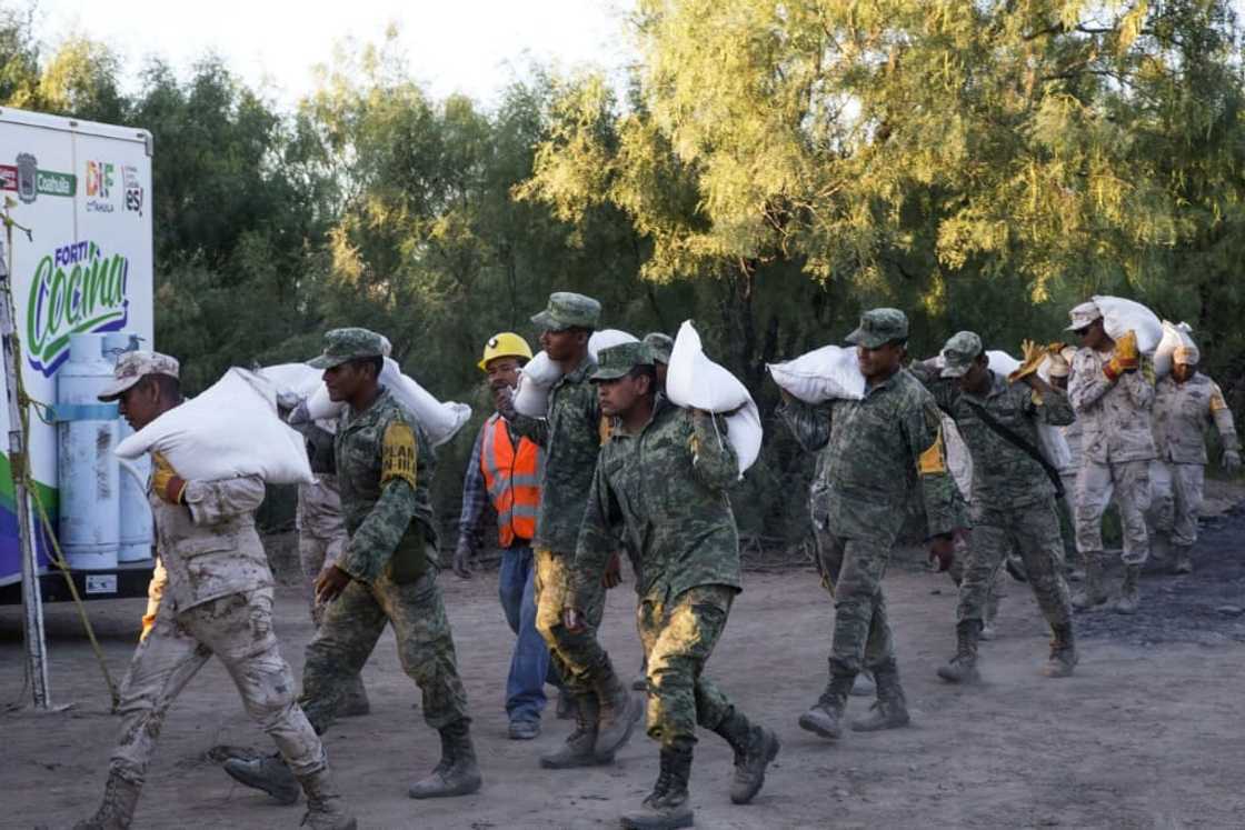 Mexican soldiers carry sand bags near the coal mine where rescuers are battling to save 10 workers trapped for nearly a week Mexican soldiers carry sand bags near the coal mine where rescuers are battling to save 10 workers trapped for nearly a week