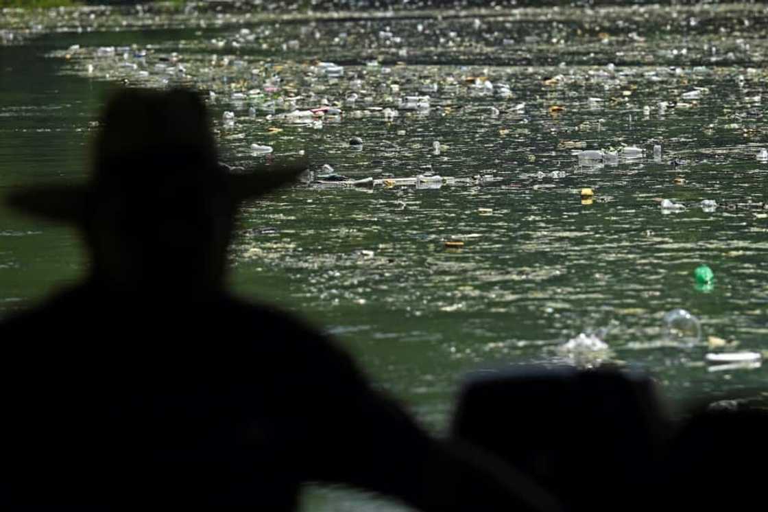 A fisherman looks out over the carpet of plastic waste covering the Cerron Grande reservoir in Potonico, El Salvador A fisherman looks out over the carpet of plastic waste covering the Cerron Grande reservoir in Potonico, El Salvador