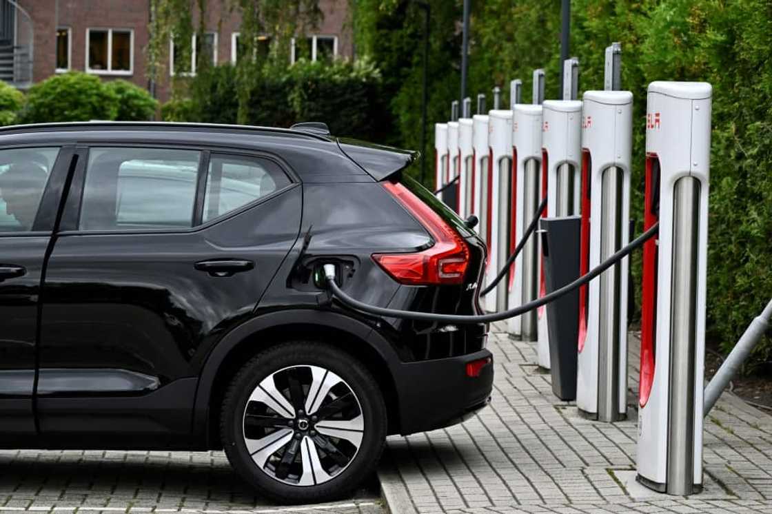 An electric car charges at a charging point reserved for Tesla cars An electric car charges at a charging point reserved for Tesla cars