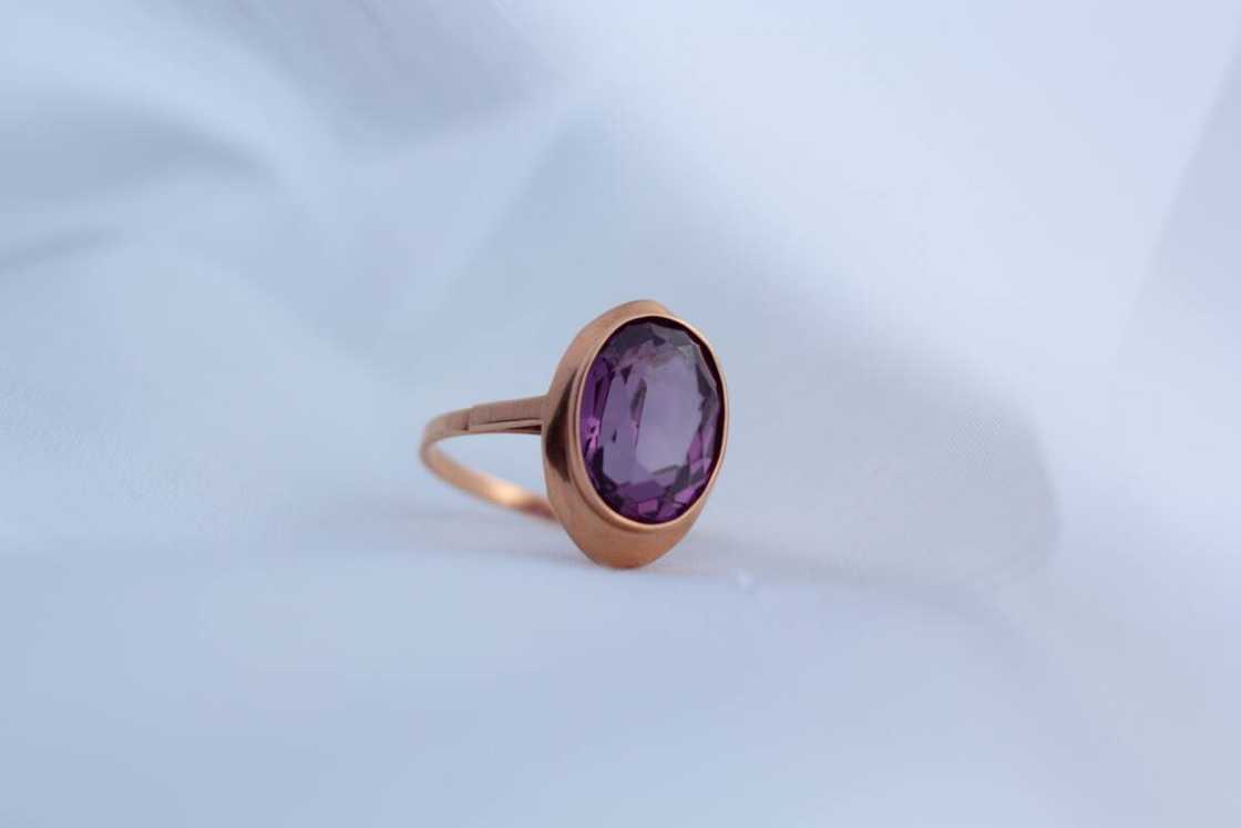 Closeup of gold ring with amethyst gemstone.