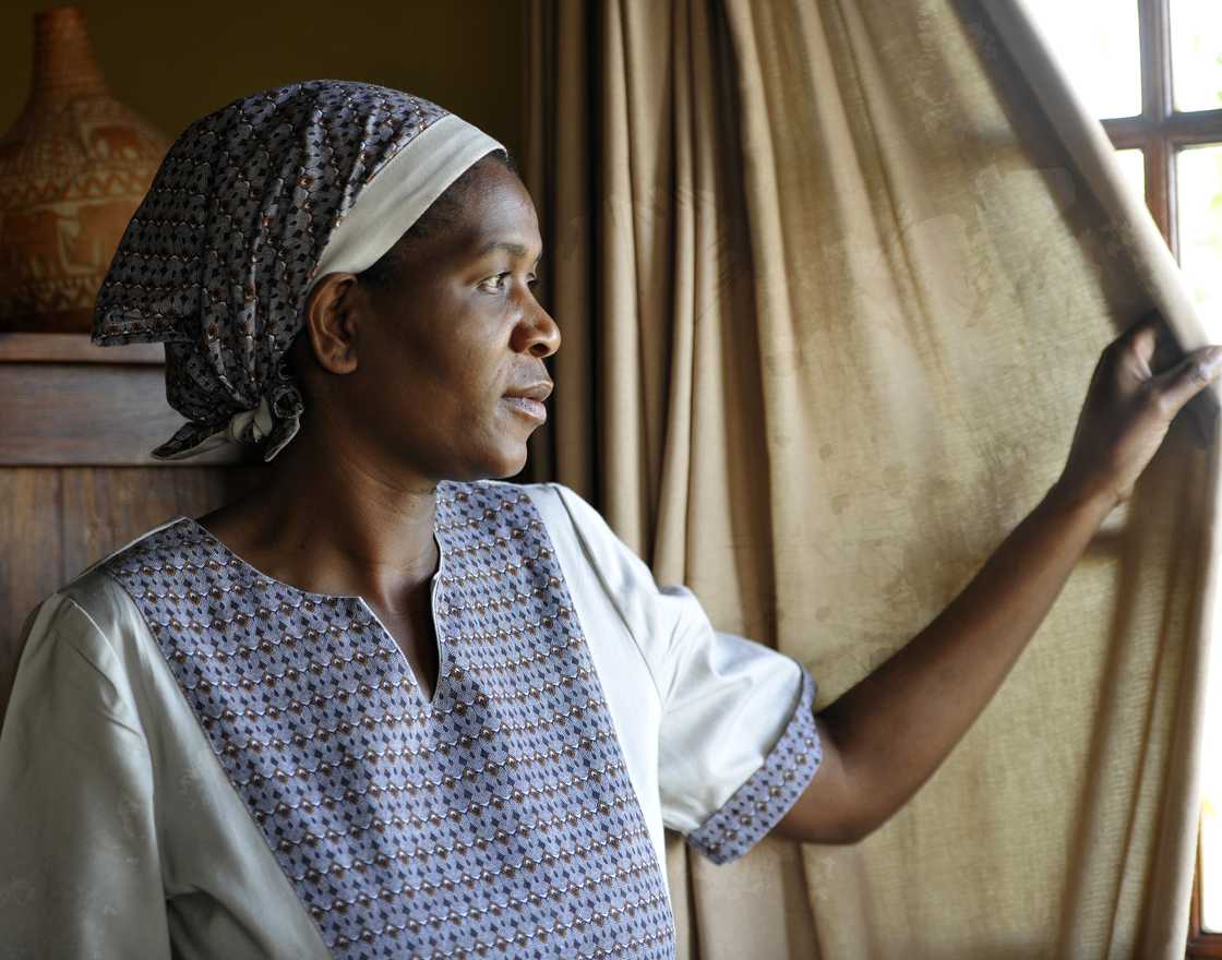South African maid looking out the window at Klasserie Game Lodge