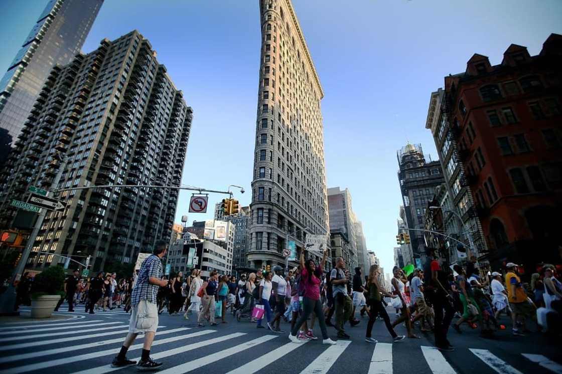 People march past the iconic Flatiron Building in New York