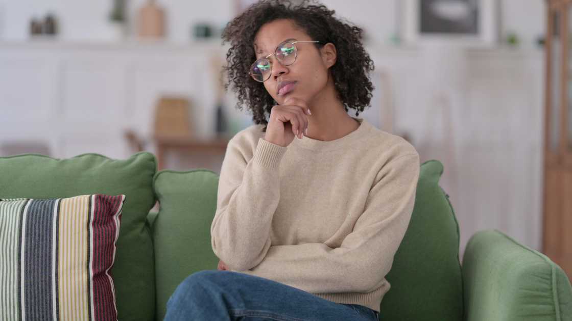 A woman sitting on sofa thinking