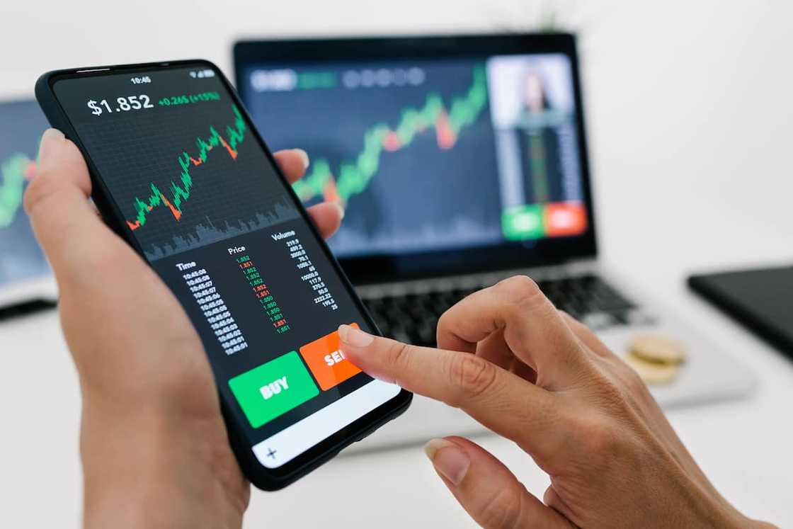 Woman trading currencies using a mobile app Woman trading currencies using a mobile app
