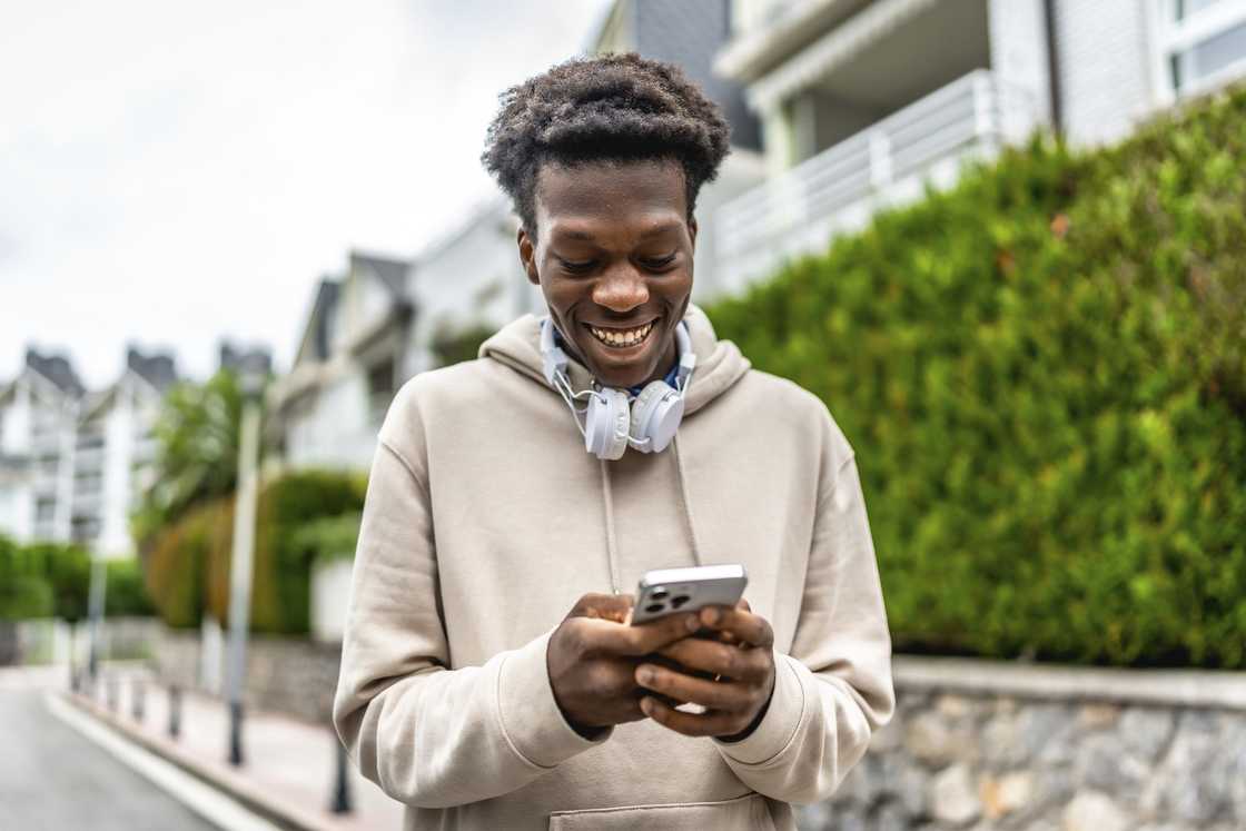 A man smiles at his phone. A man smiles at his phone.