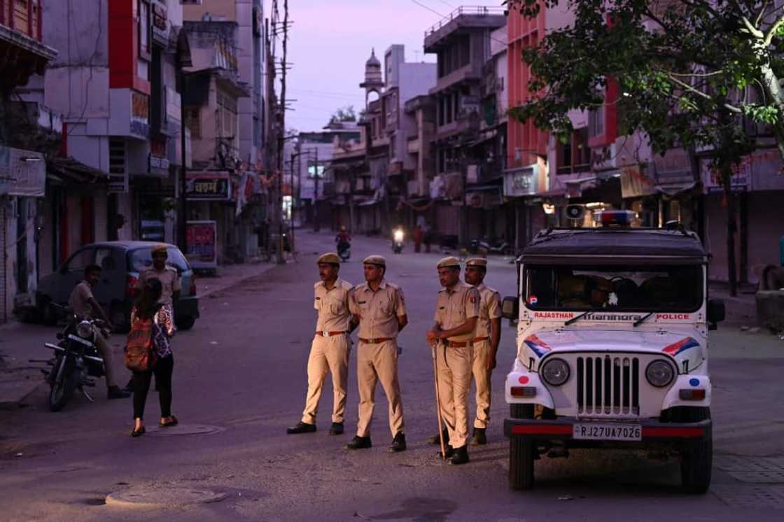 Police stand guard along a deserted street in Udaipur during a curfew imposed by authorities following the killing of Hindu tailor Kanhaiya Lal, allegedly by two Muslim men Police stand guard along a deserted street in Udaipur during a curfew imposed by authorities following the killing of Hindu tailor Kanhaiya Lal, allegedly by two Muslim men