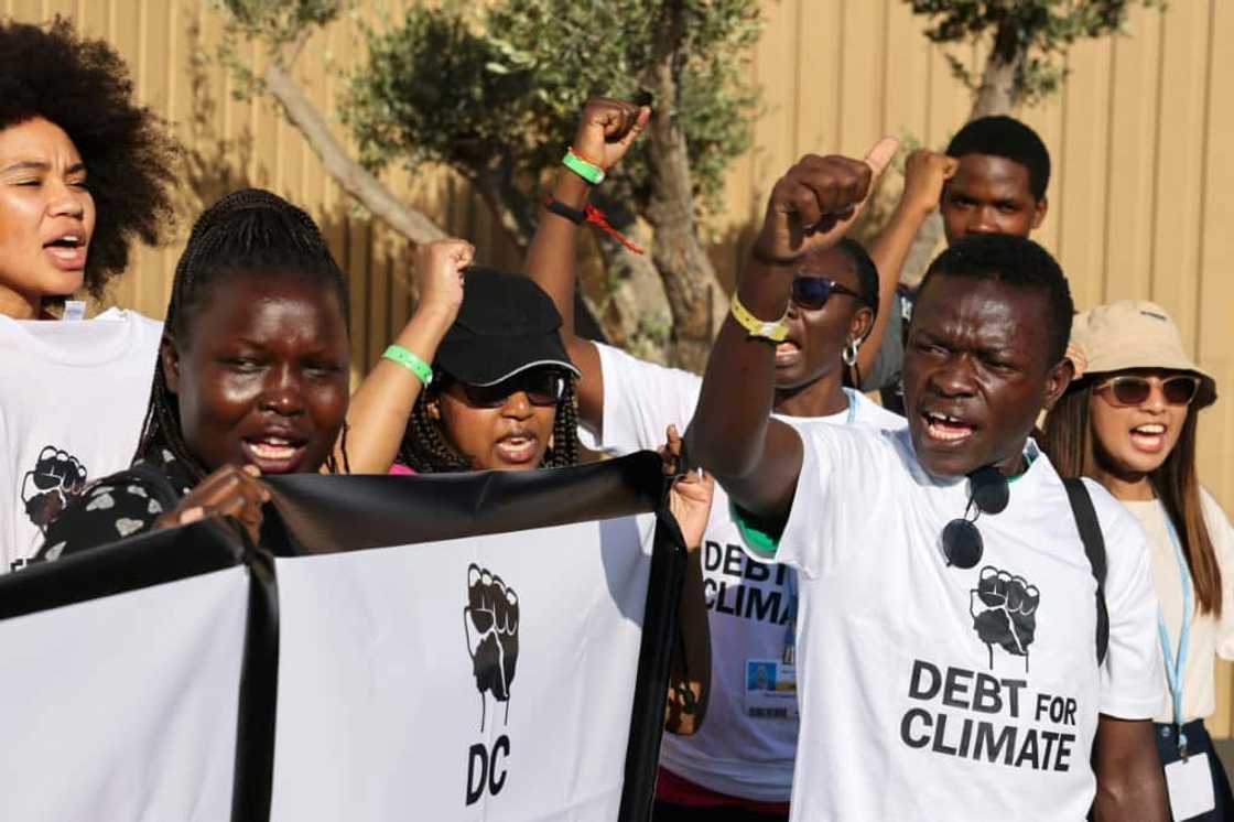 Activists lift banners as they stage a protest during the COP27 climate conference in the Egyptian Red Sea resort of Sharm el-Sheikh