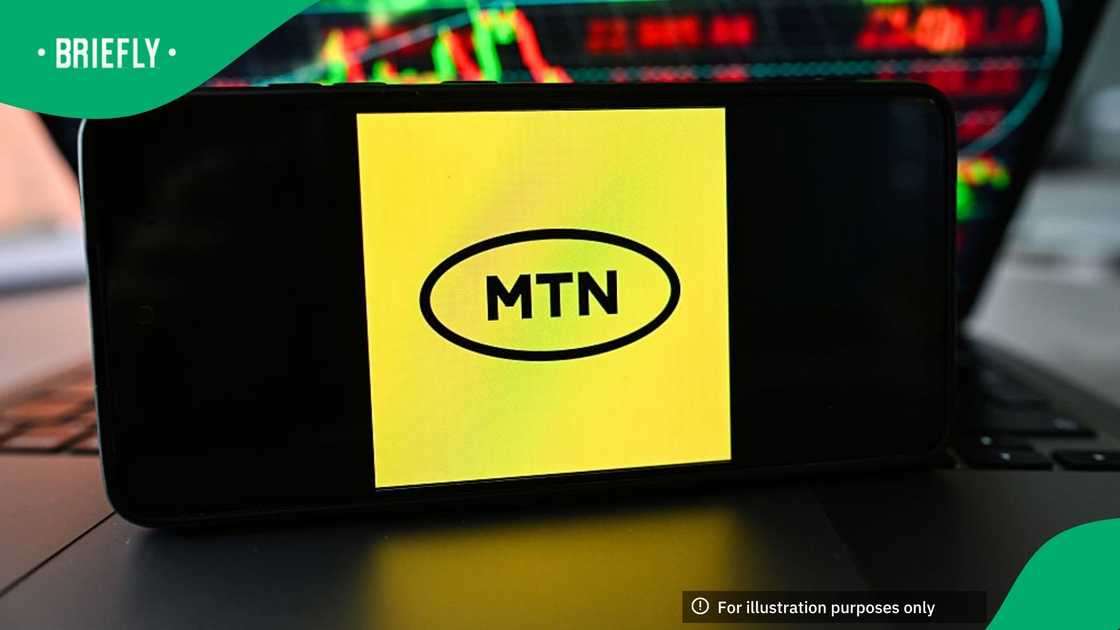 In this photo illustration, the MTN logo is displayed on a smartphone with stock market percentages in the background