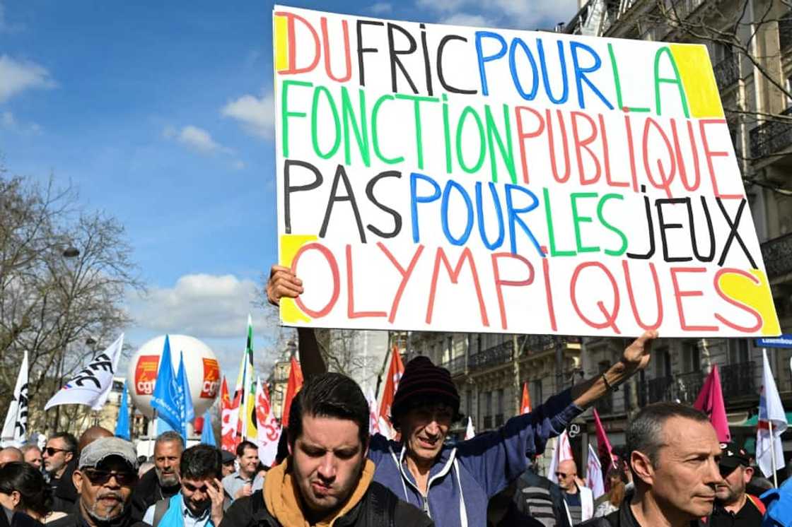 A protester holds a banner reading 'Cash for civil services, not for the Olympic Games' during a demonstration last week