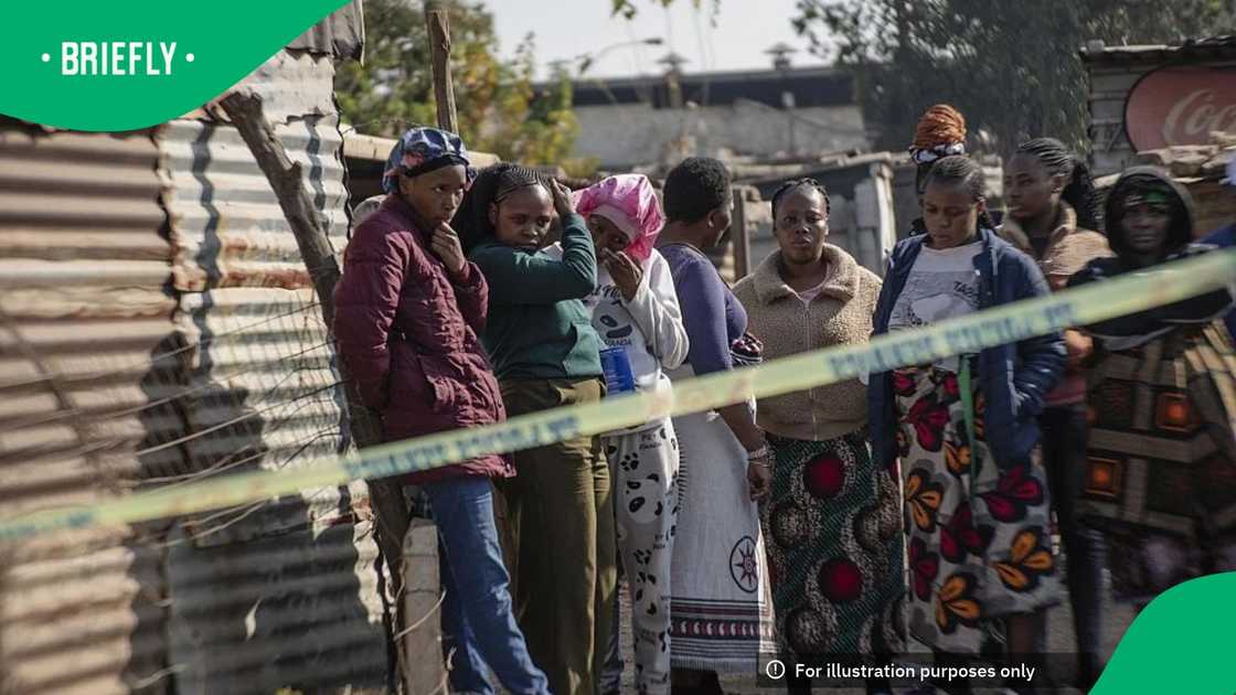People watch as an investigation is conducted at the scene following the attack that at least 12 people were killed and nine others injured in a shooting at the informal settlement of Jumpers in the Cleveland area of Johannesburg, on June 10, 2026 People watch as an investigation is conducted at the scene following the attack that at least 12 people were killed and nine others injured in a shooting at the informal settlement of Jumpers in the Cleveland area of Johannesburg, on June 10, 2026
