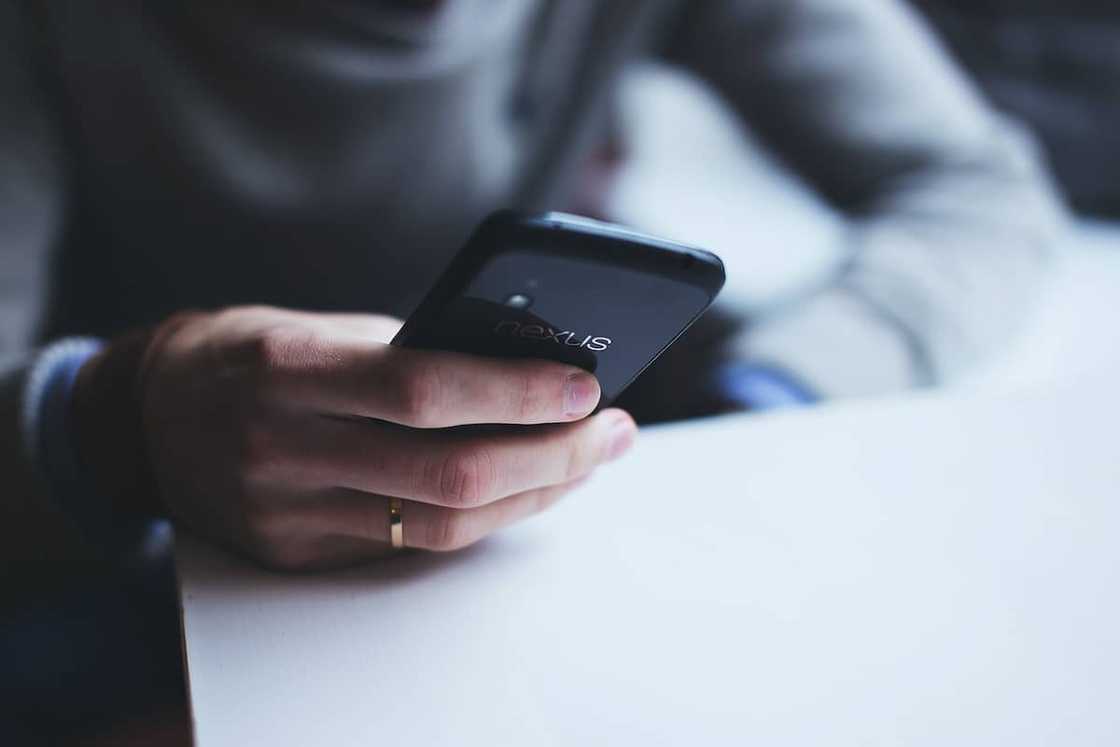 A person dialing a phone A person dialing a phone