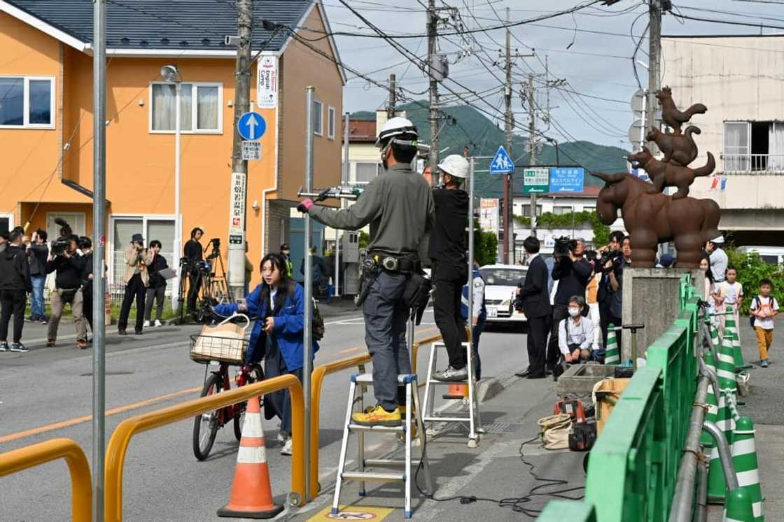 Workers install a barrier to block the sight of  Mount Fuji in the town of Fujikawaguchiko