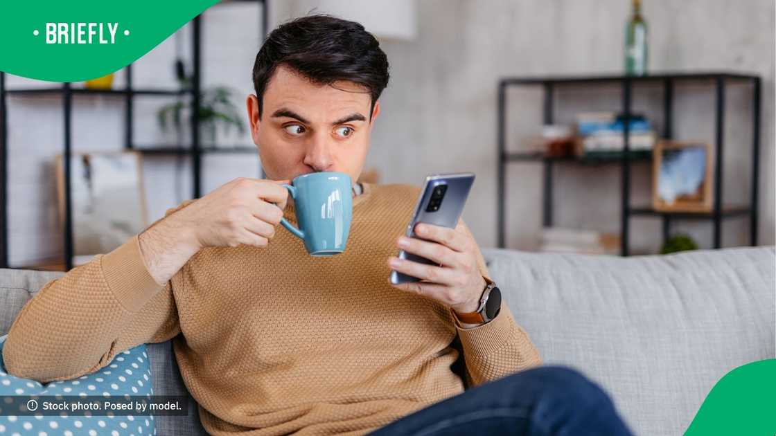 A shocked man looking at his phone. A shocked man looking at his phone.