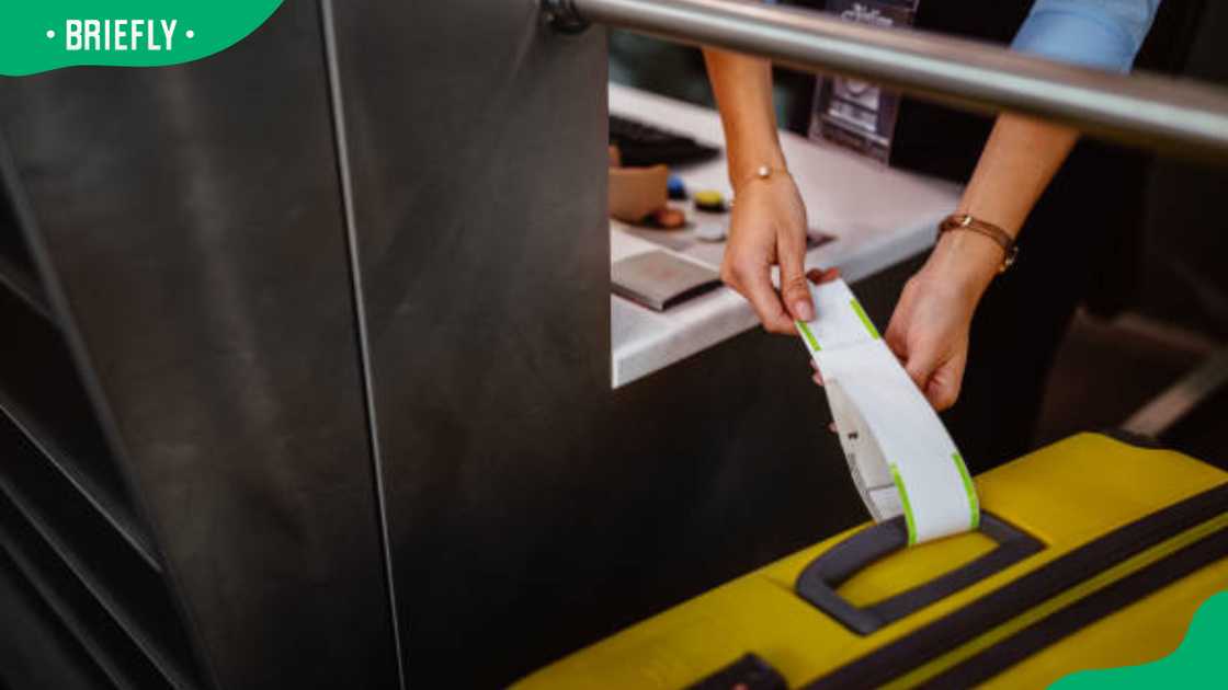 Airport check-in counter employee attaching tag on luggage Airport check-in counter employee attaching tag on luggage