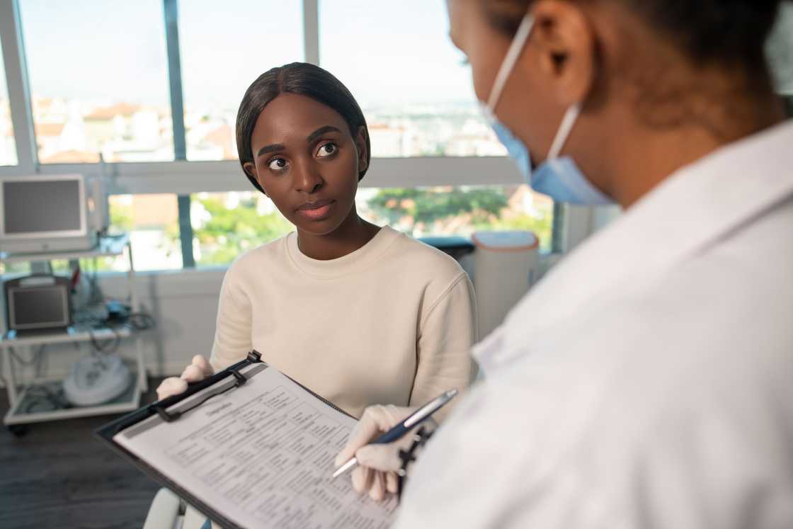 A lady receives her test report from a doctor A lady receives her test report from a doctor