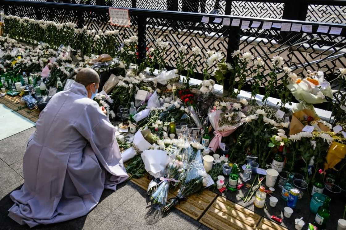 At a makeshift memorial close to the narrow alleyway at the epicenter of the disaster, Buddhist monks chanted prayers for the dead