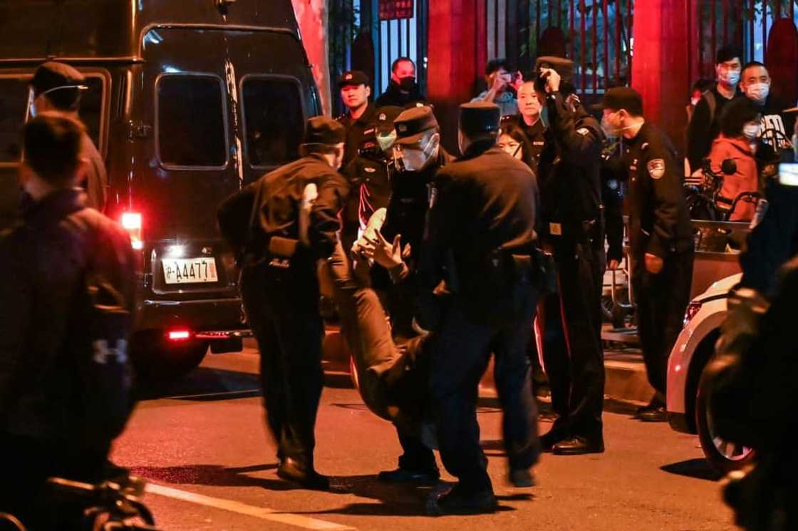 Large crowds congregated in downtown Shanghai on Sunday where police clashed with protesters as they tried to stop groups converging at Wulumuqi street