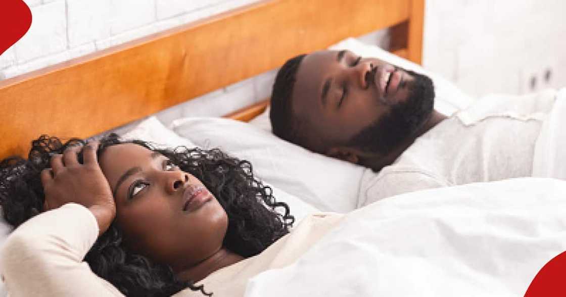 A couple in bed with a man snoring while a woman is deep in thought A couple in bed with a man snoring while a woman is deep in thought