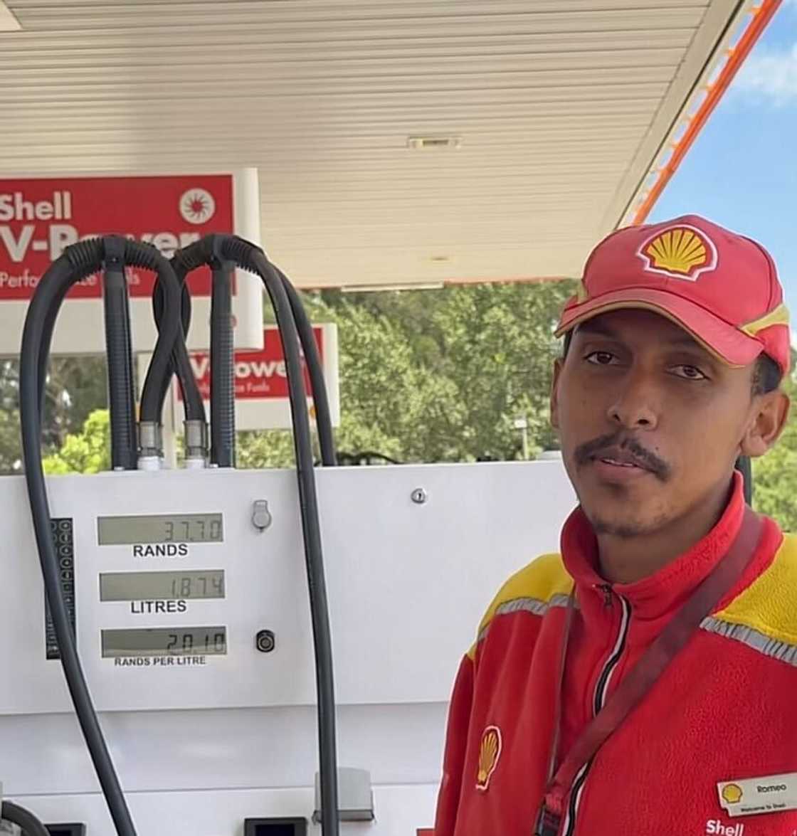 A petrol attendant filled up a vehicle at the pump.