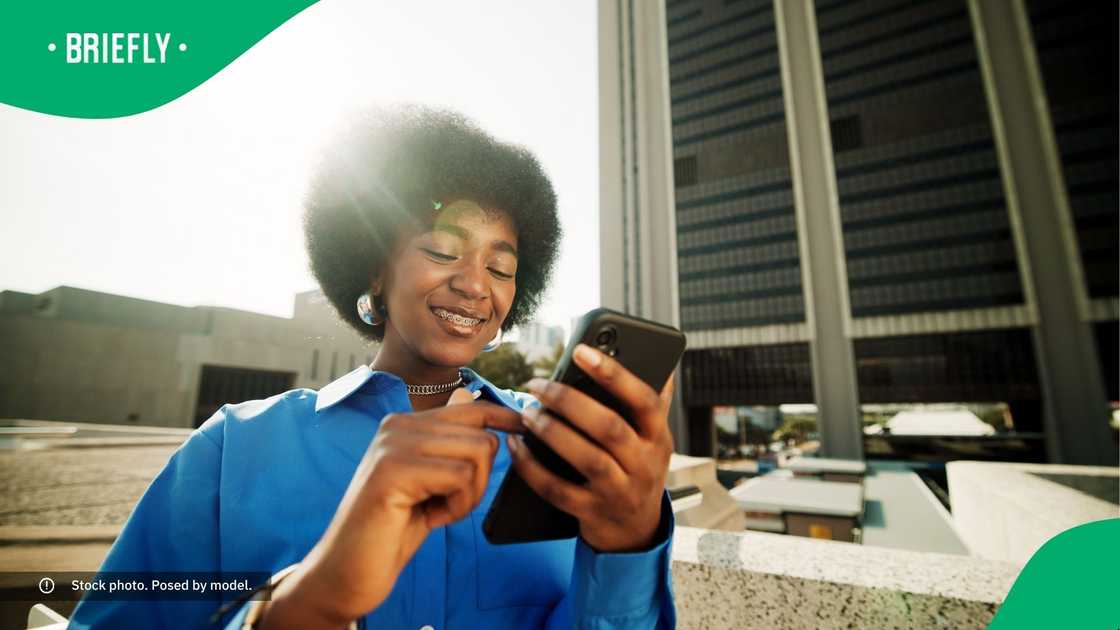 A woman smiling at her phone. A woman smiling at her phone.