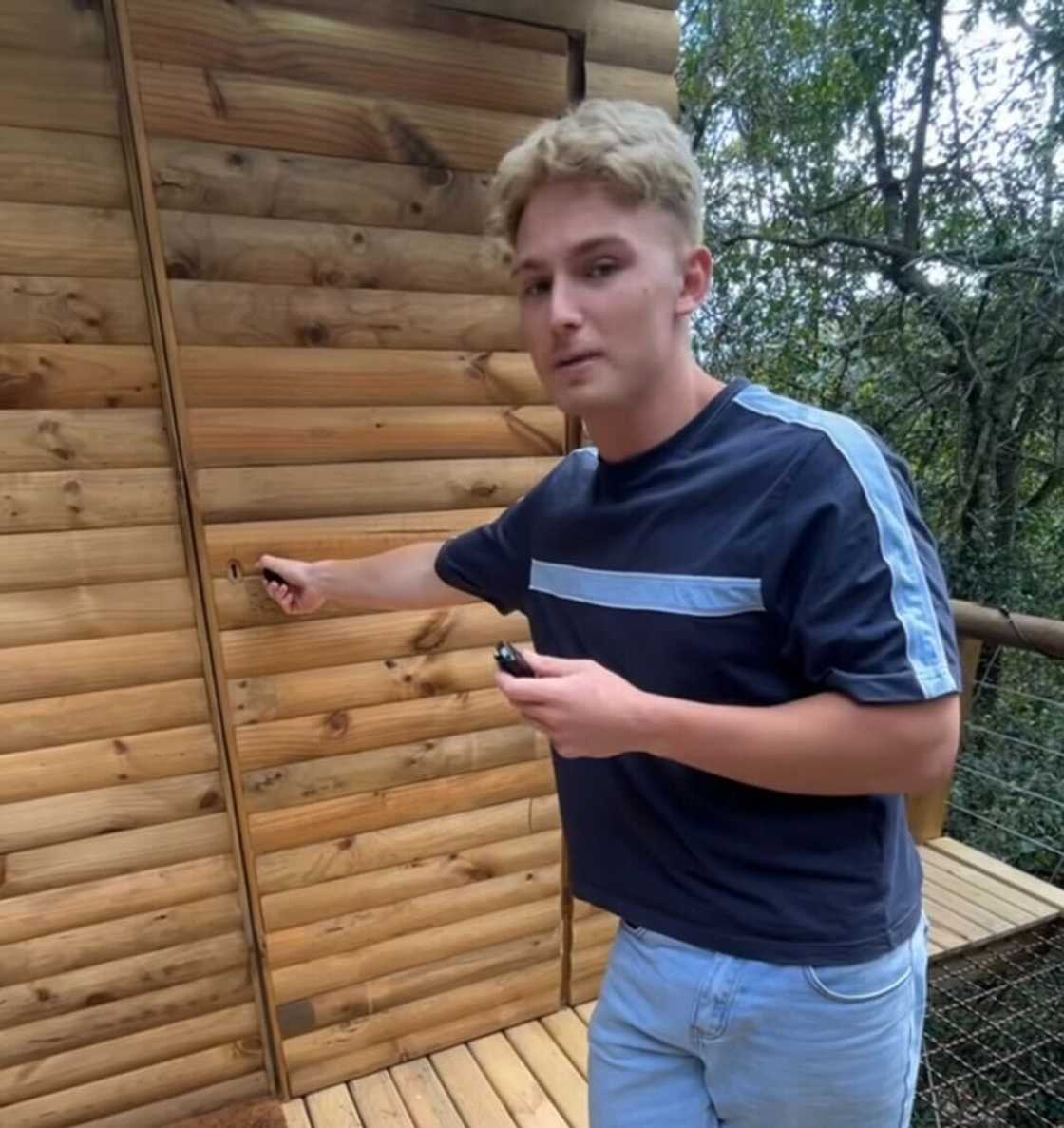 A man opening the door to a wooden cabin in the Western Cape.