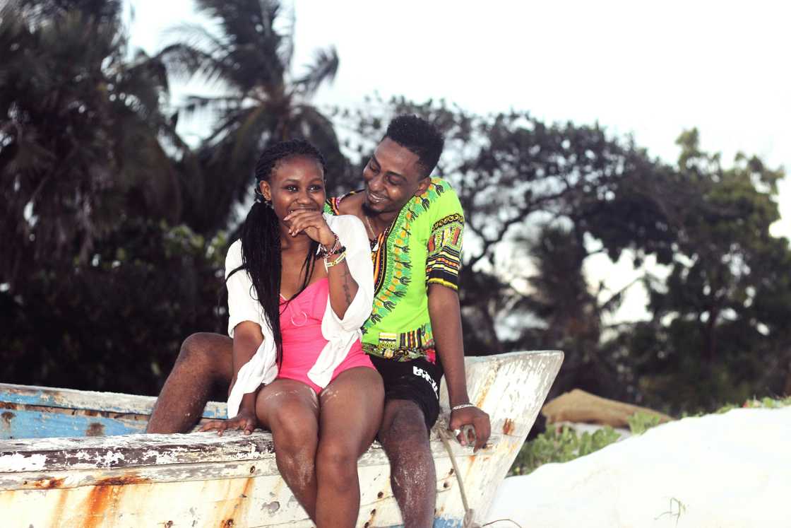 A young black couple sitting on a boat A young black couple sitting on a boat