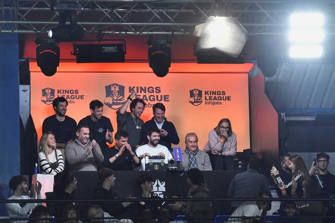 Spanish former football player and president of the Kings League Gerard Pique (C) and his father (2R) pick and show a game-changing card Spanish former football player and president of the Kings League Gerard Pique (C) and his father (2R) pick and show a game-changing card