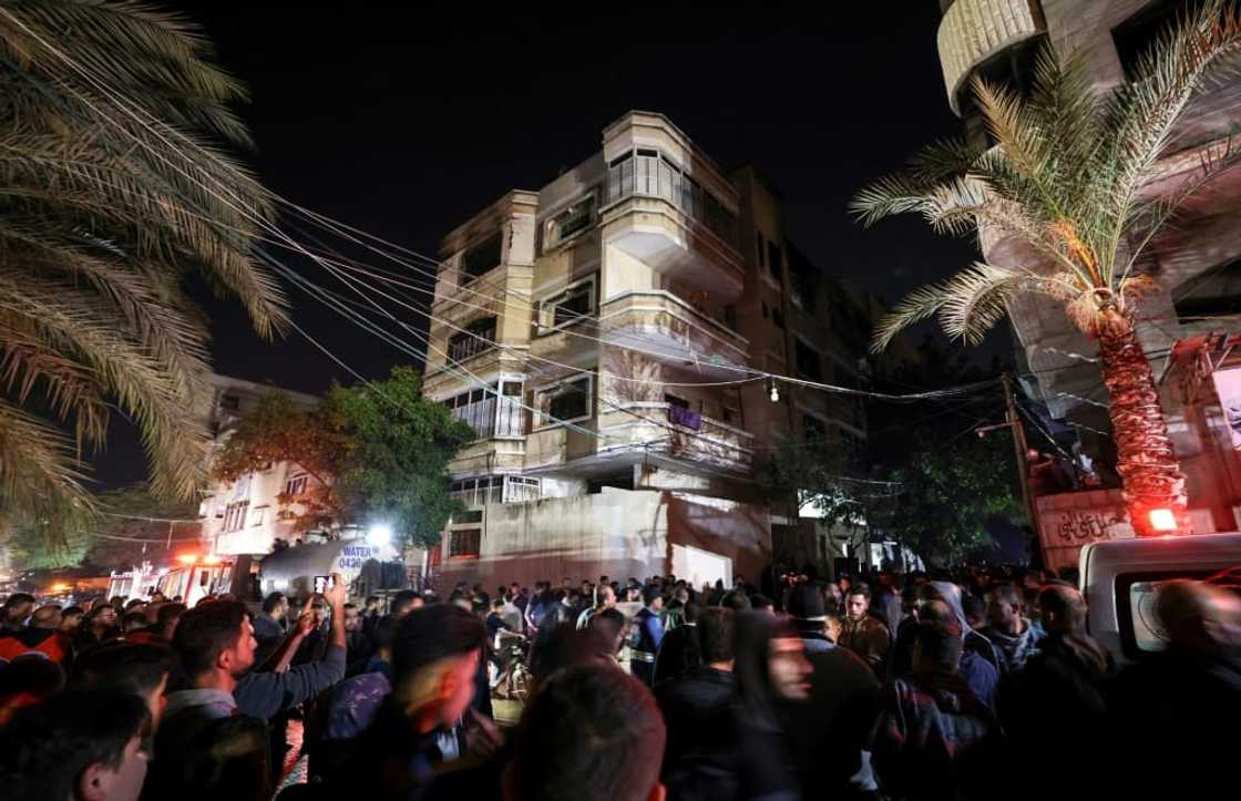 A large crowd of onlookers gathered on the street outside the multi-storey home from which plumes of smoke billowed A large crowd of onlookers gathered on the street outside the multi-storey home from which plumes of smoke billowed