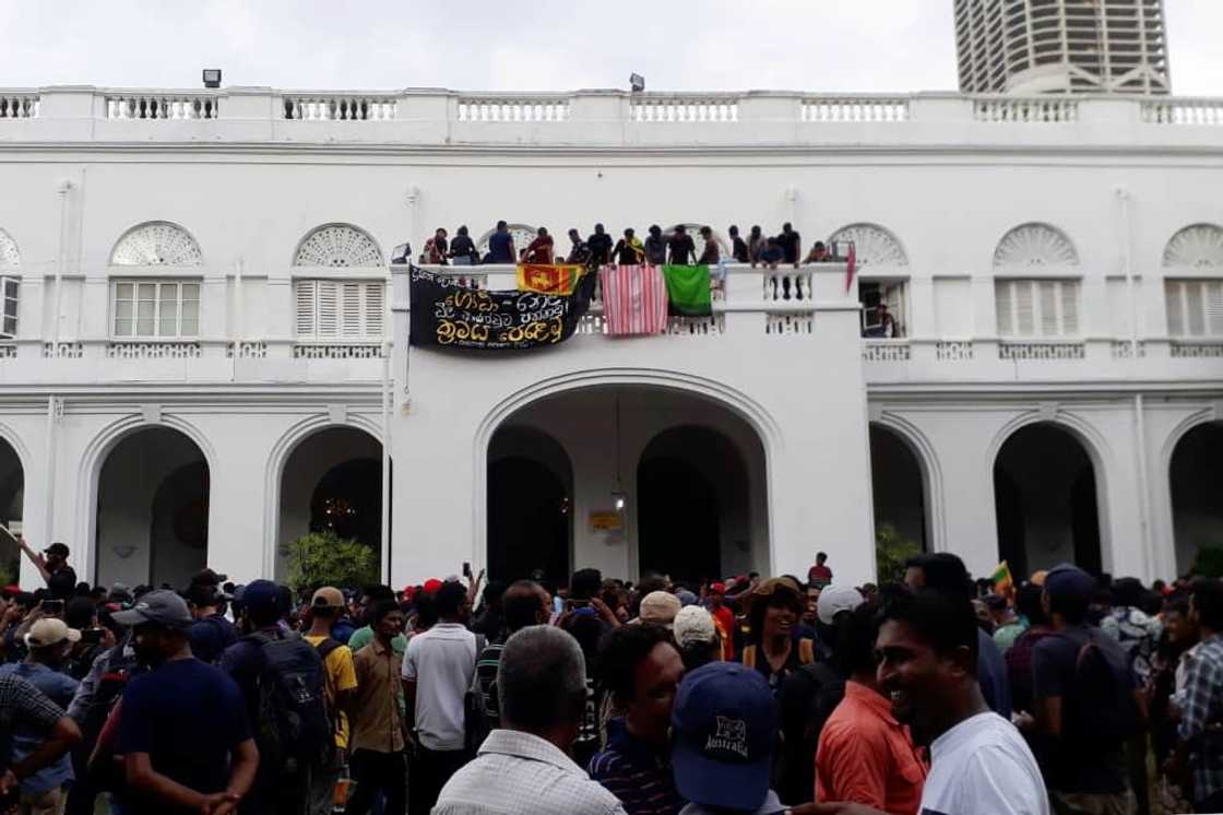 Protesters are seen on the balcony of the presidential palace on Saturday