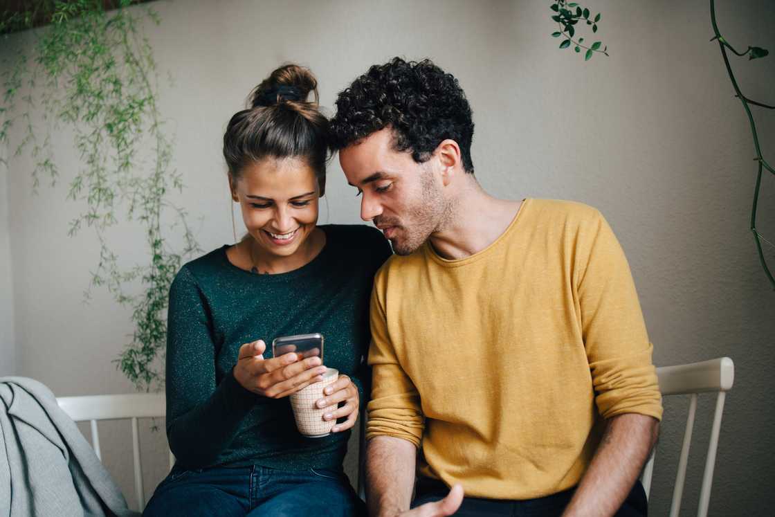 People smiling at a phone. People smiling at a phone.