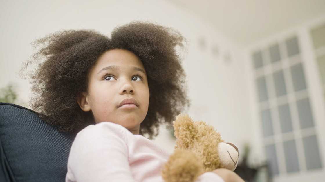 A sad little girl holding a stuffed toy A sad little girl holding a stuffed toy