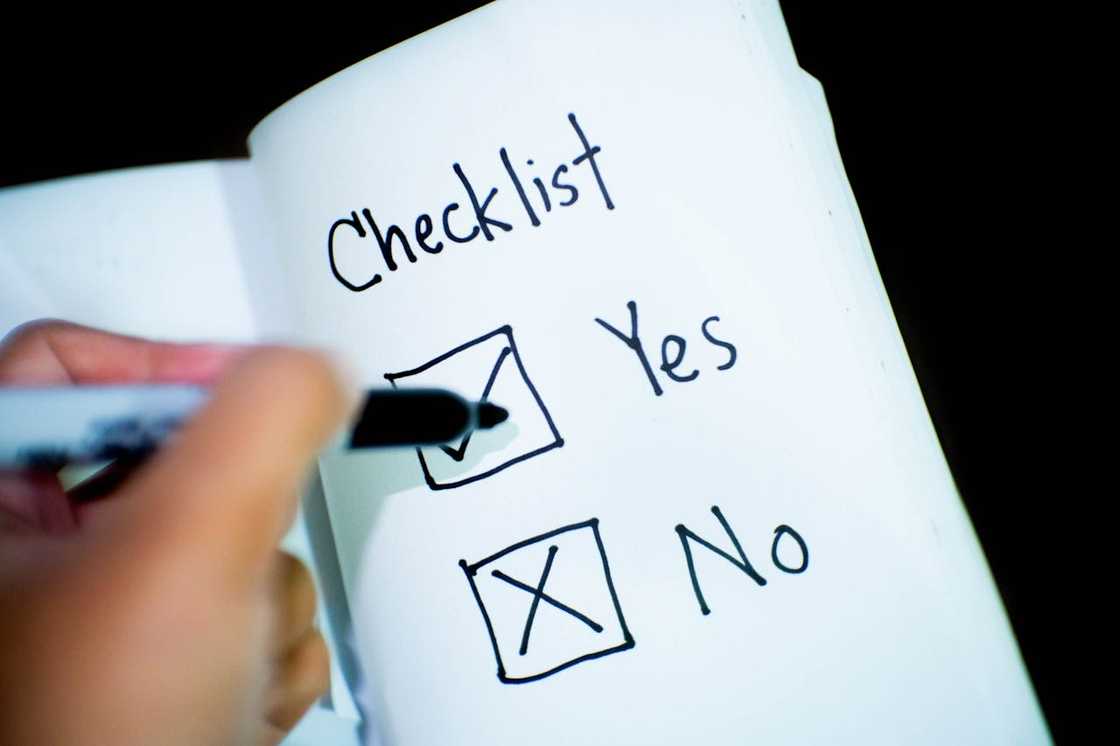 A hand ticking “Yes” on a handwritten checklist.