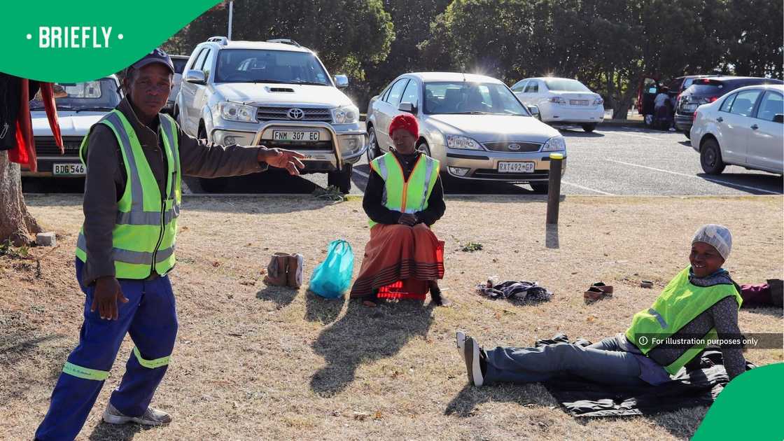 The picture showed car guards sitting down at a parking lot The picture showed car guards sitting down at a parking lot