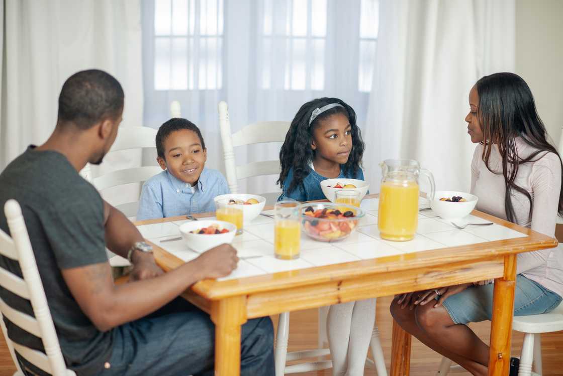 A family gathers at the breakfast table for a discussion. A family gathers at the breakfast table for a discussion.