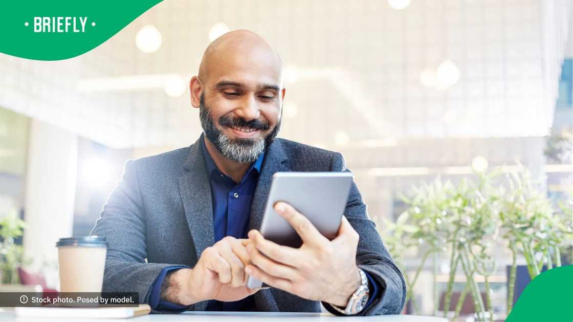 Businessman smiling at his tablet. Businessman smiling at his tablet.