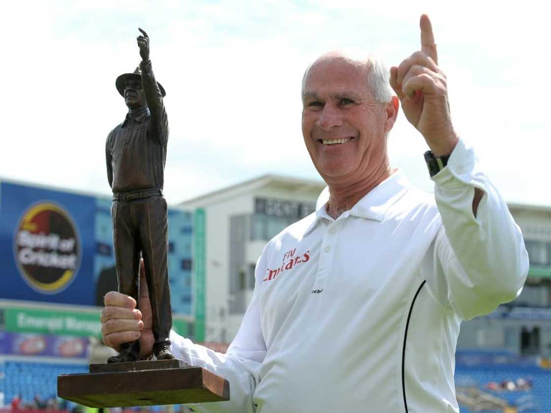 South African Rudi Koertzen holds a statue of himself while umpiring his final Test, between Australia and Pakistan in England during 2010.