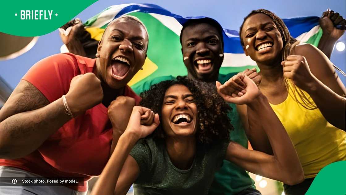 A group of cheerful people with a South African flag. A group of cheerful people with a South African flag.