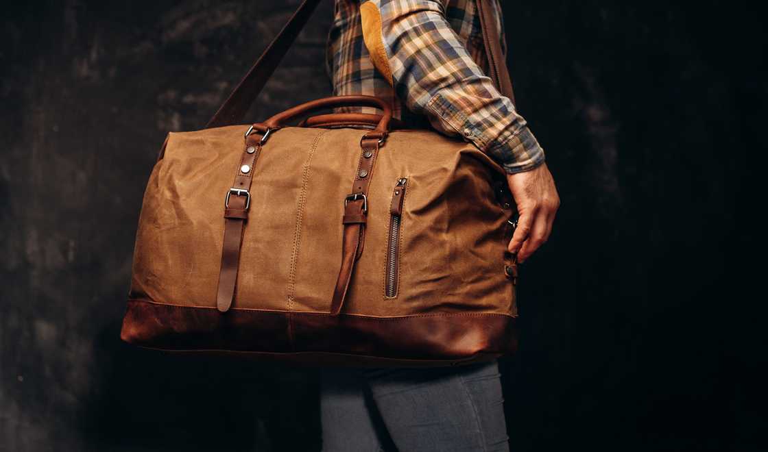 Brown duffel bag on men's shoulder.