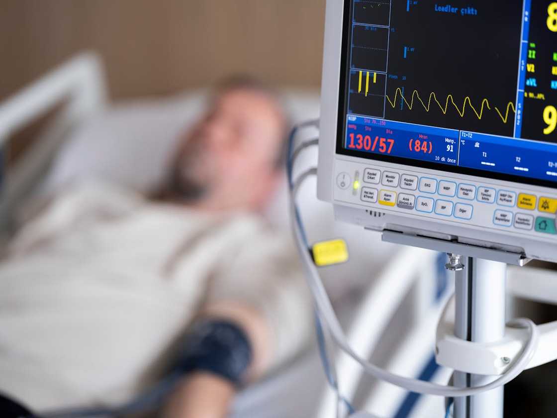 A bedside monitor shows heart rate readings while a patient rests. A bedside monitor shows heart rate readings while a patient rests.