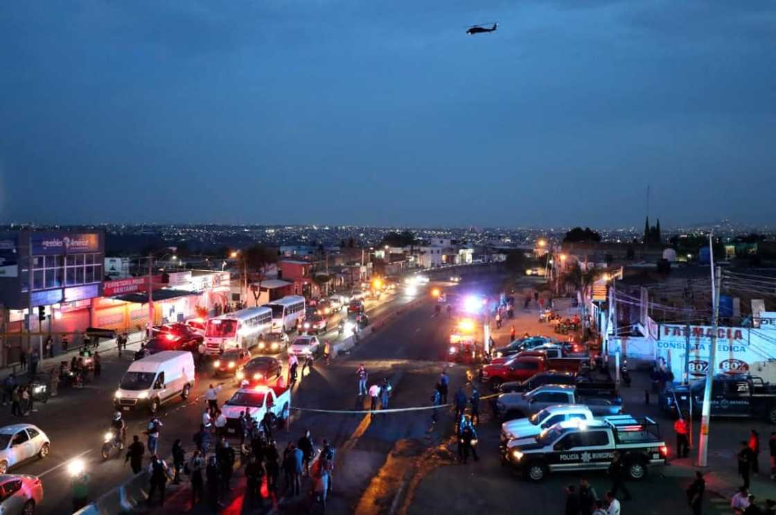 Police inspect an area where suspected gang members set a bus on fire in the western state of Jalisco