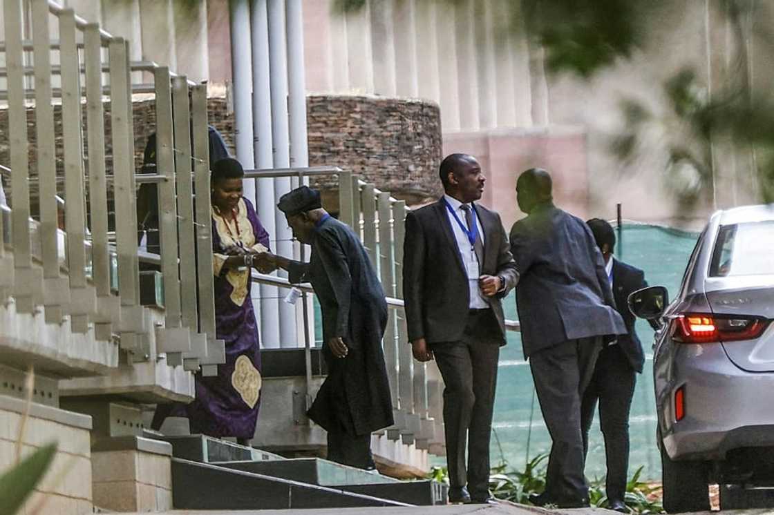 African Union envoy and former Nigerian president Olusegun Obasanjo, wearing a cap, is greeted on the second day of peace talks between the Ethiopian government and Tigrayan People's Liberation Front (TPLF in Pretoria