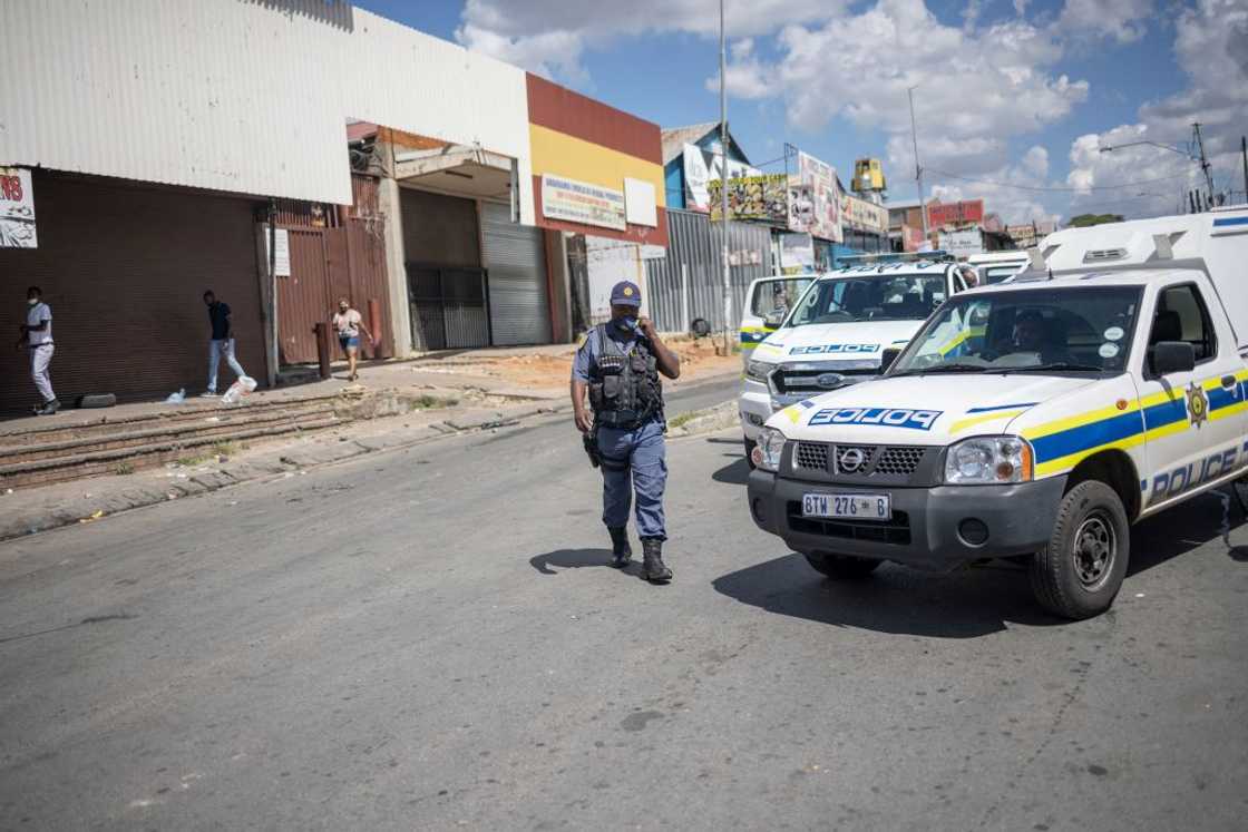 A police officer walks next to a SAPS van A police officer walks next to a SAPS van