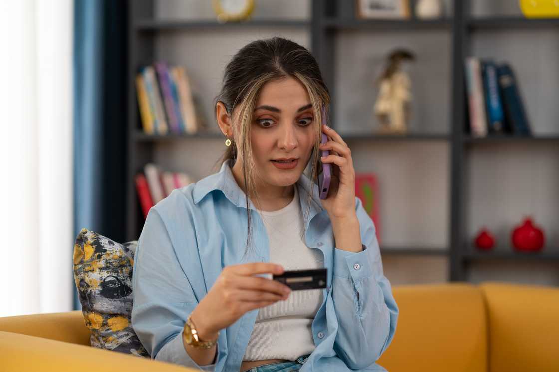A stock photo of a woman staring at her bank card