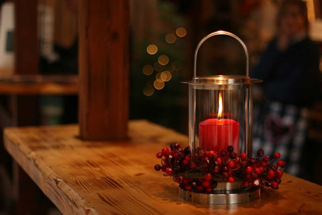 Red lighted candle on a brown wooden frame