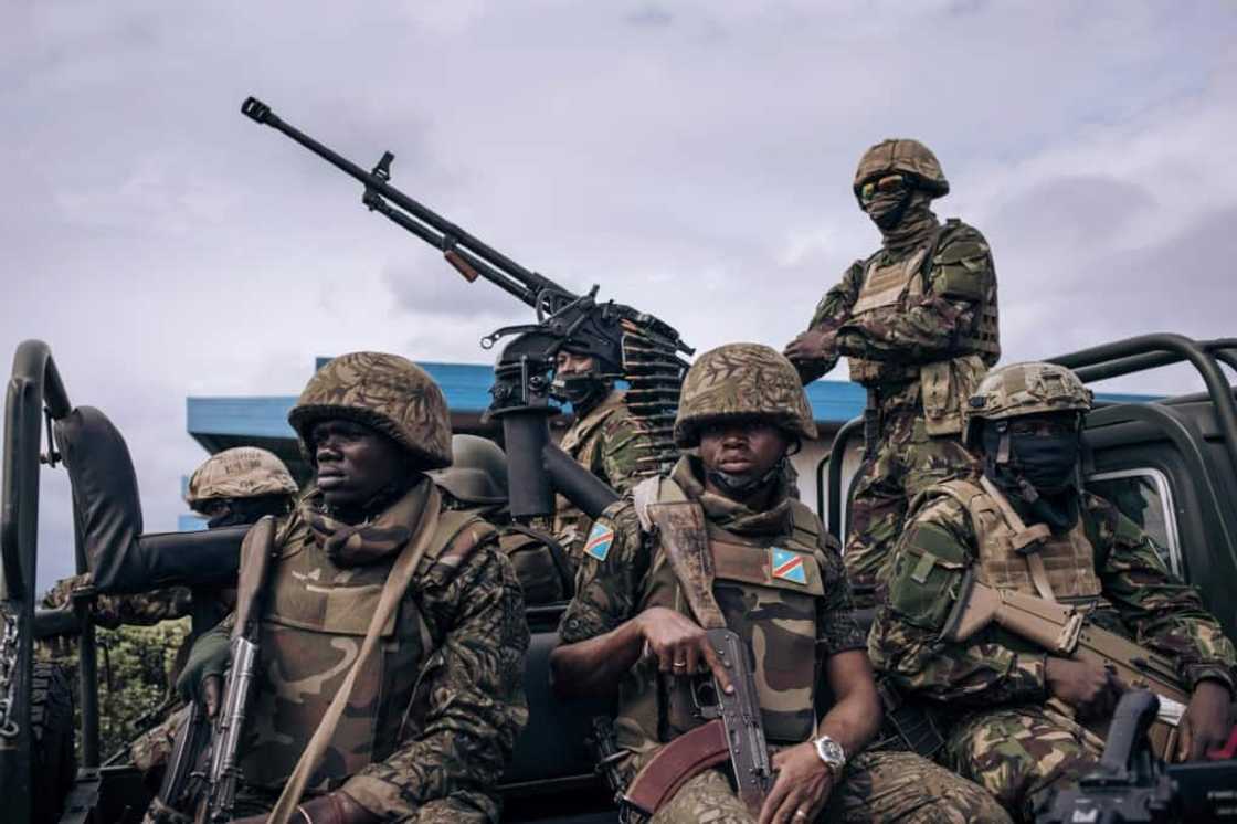 Kenyan and Congolese troops stand guard at the airport in Goma, in the eastern Democratic Republic of Congo, as former Kenyan president Uhuru Kenyatta, now a regional negotiator, landed on November 15, 2022 Kenyan and Congolese troops stand guard at the airport in Goma, in the eastern Democratic Republic of Congo, as former Kenyan president Uhuru Kenyatta, now a regional negotiator, landed on November 15, 2022