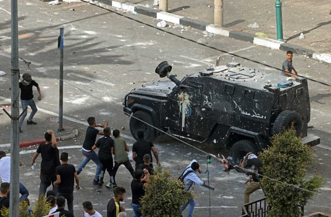 Protesters hurl stones at Palestinian security forces as they carry out an arrest operation in the main northern West Bank city of Nablus