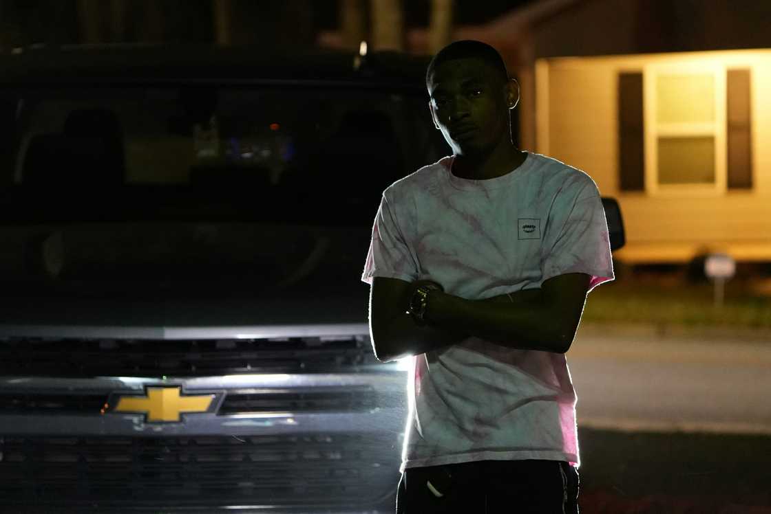 A concerned man standing infront of his car