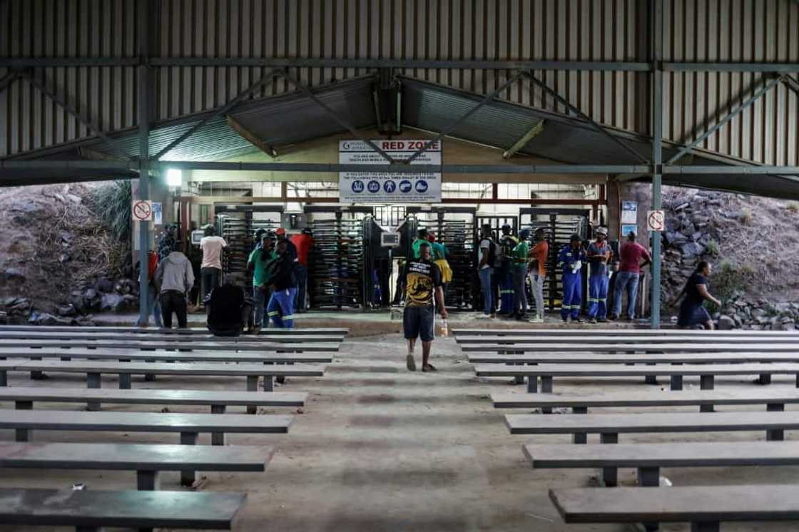 Police and security forces patrolled the area Tuesday evening as about 100 miners sang protest songs outside the mine Police and security forces patrolled the area Tuesday evening as about 100 miners sang protest songs outside the mine